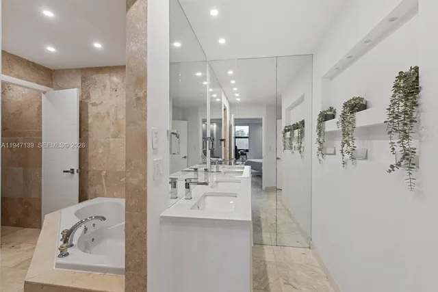 a bathroom with a bathtub shower sink and mirror