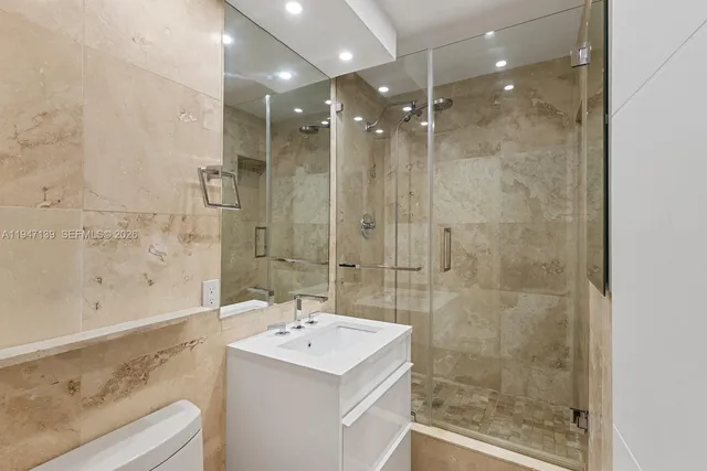 a bathroom with a bathtub shower sink vanity and a mirror