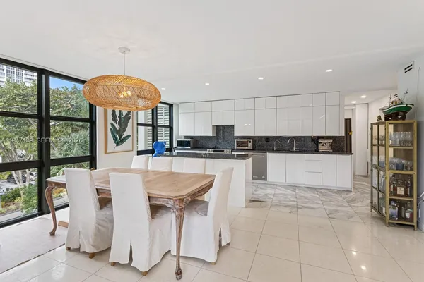 a kitchen with granite countertop a table chairs microwave and cabinets