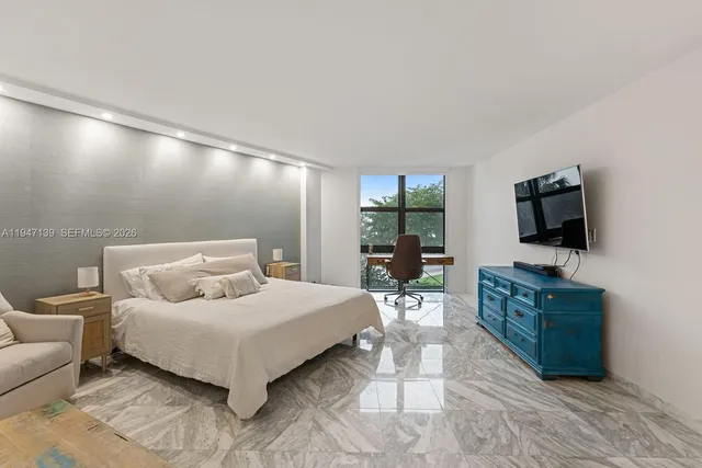 a bedroom with a bed and a flat screen television