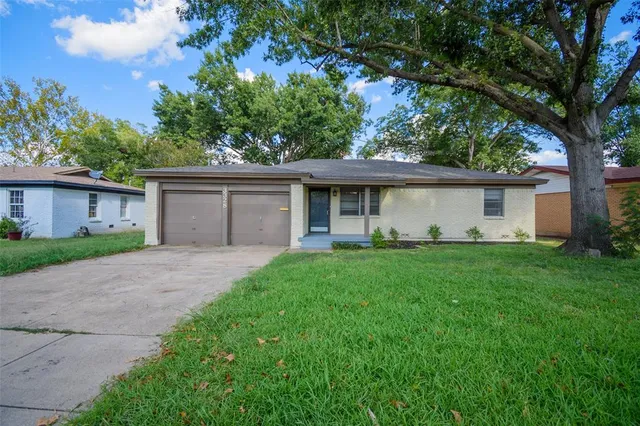 a front view of a house with a garden and yard