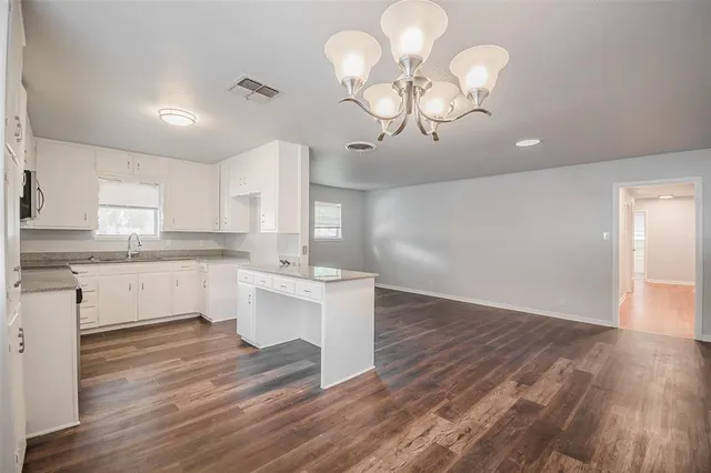 a kitchen with a white cabinets stainless steel appliances and wooden floor