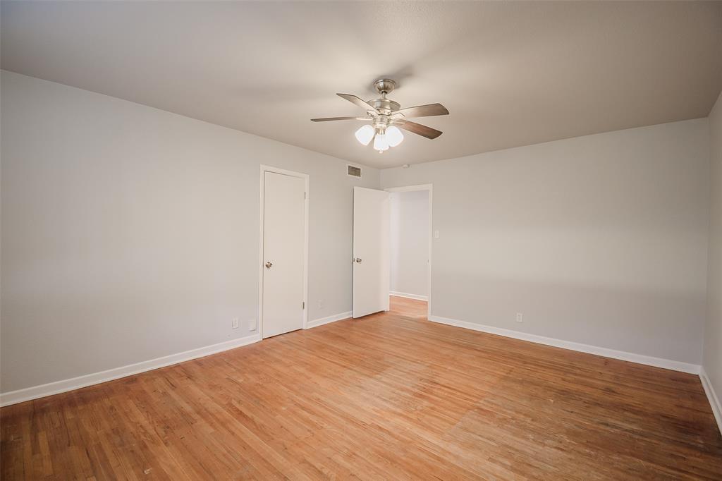 3328 Hedrick Street Fort Worth, TX 76111 - Photo 17 of 28 a view of an empty room with wooden floor