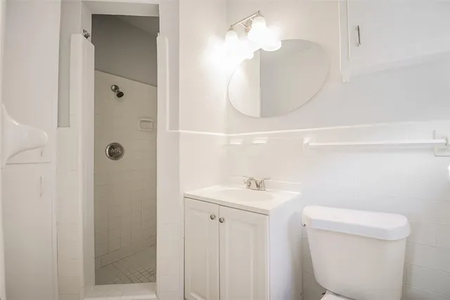 a bathroom with a sink a toilet and shower