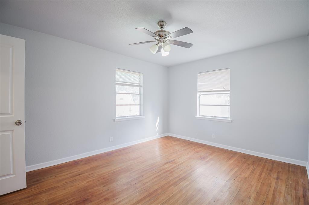 3328 Hedrick Street Fort Worth, TX 76111 - Photo 22 of 28 a view of an empty room with wooden floor and a window