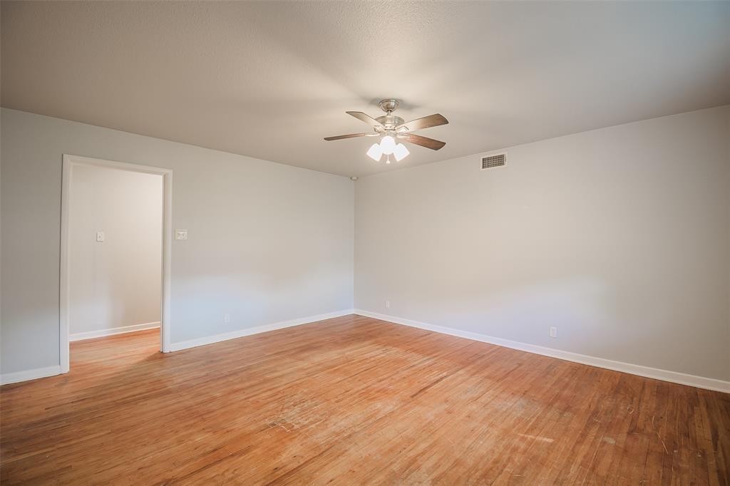 3328 Hedrick Street Fort Worth, TX 76111 - Photo 5 of 28 wooden floor in an empty room with a window