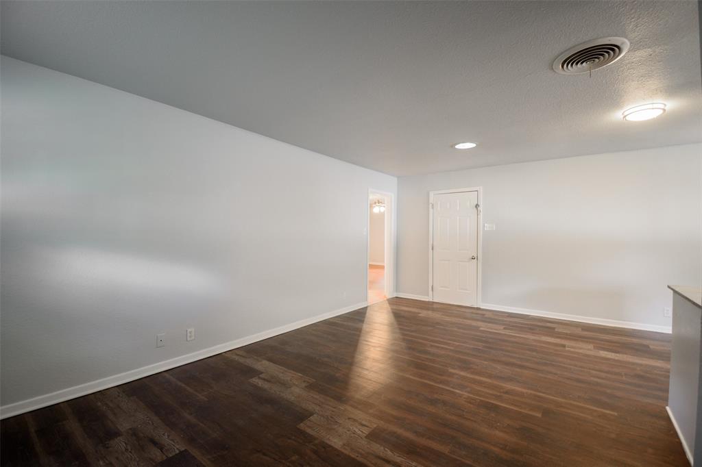 3328 Hedrick Street Fort Worth, TX 76111 - Photo 9 of 28 an empty room with wooden floor and windows