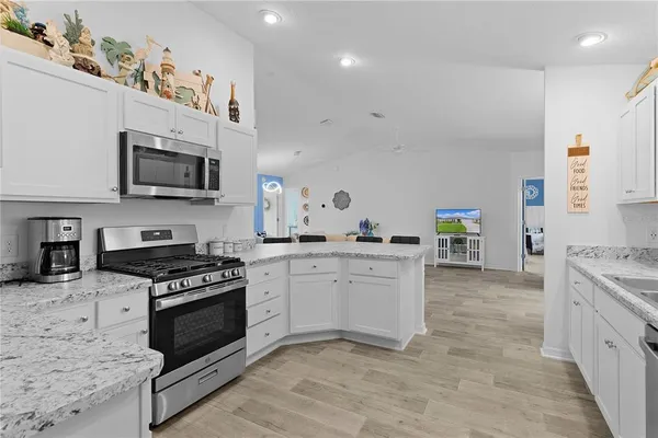 a kitchen with granite countertop a stove top oven microwave and cabinets
