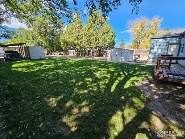 a view of a backyard with table and chairs and wooden fence