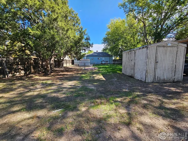 a view of a backyard with a garden and tree