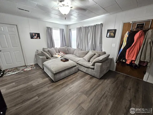a living room with furniture ceiling fan and a wooden floor