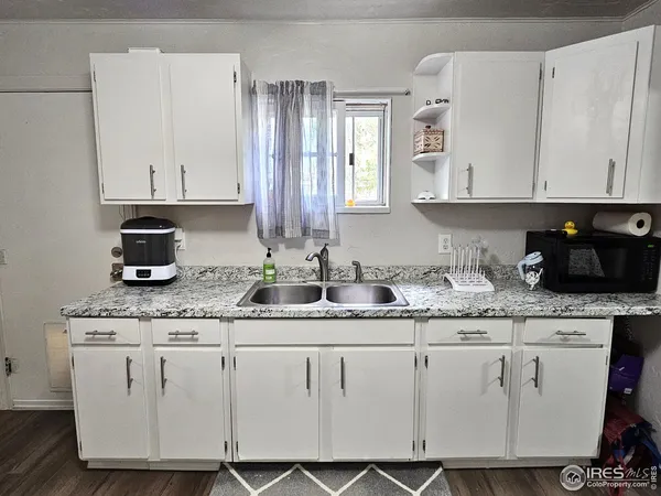 a kitchen with granite countertop white cabinets and white appliances
