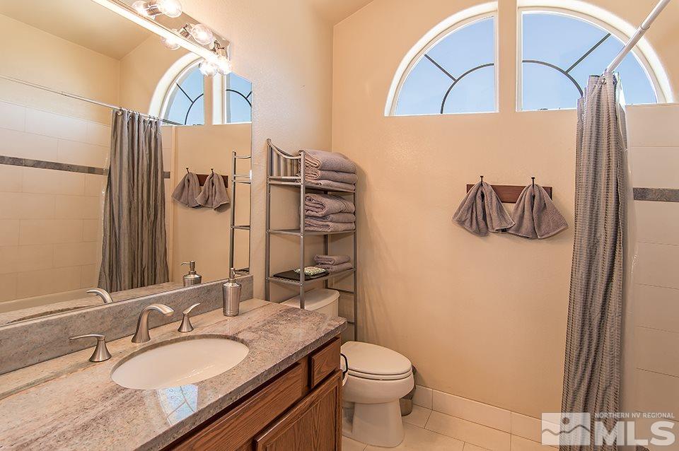 6120 Clover Meadows Court Reno, NV 89519 - Photo 19 of 21 a bathroom with a granite countertop sink and a mirror