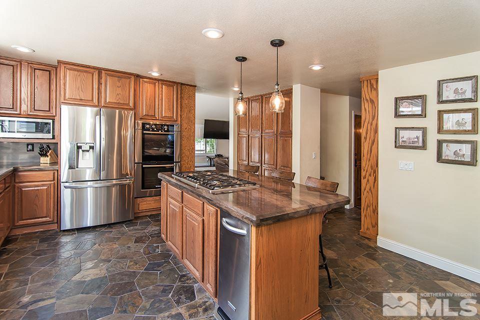 6120 Clover Meadows Court Reno, NV 89519 - Photo 9 of 21 a kitchen with stainless steel appliances granite countertop a stove a refrigerator sink and cabinets