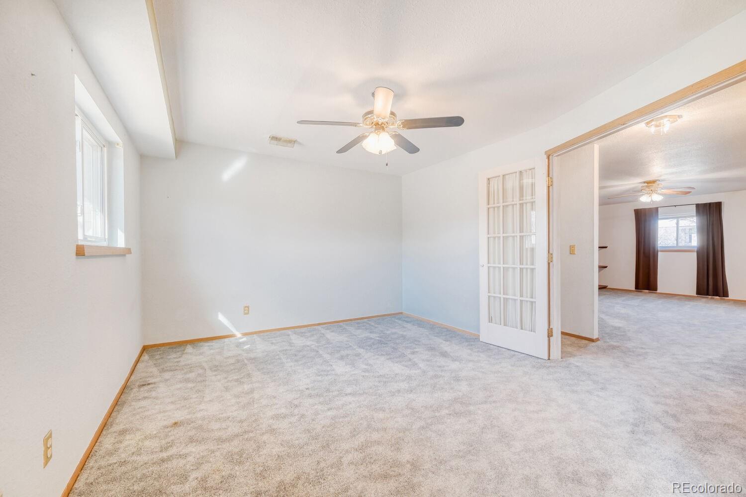430 Elizabeth Street Fort Lupton, CO 80621 - Photo 12 of 30 an empty room with chandelier fan and windows