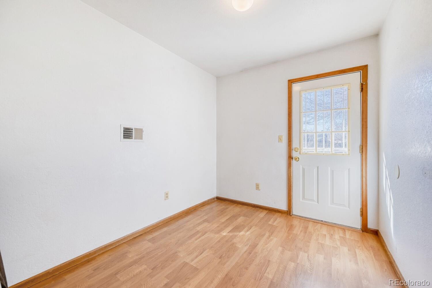 430 Elizabeth Street Fort Lupton, CO 80621 - Photo 13 of 30 a view of an empty room with wooden floor and a window