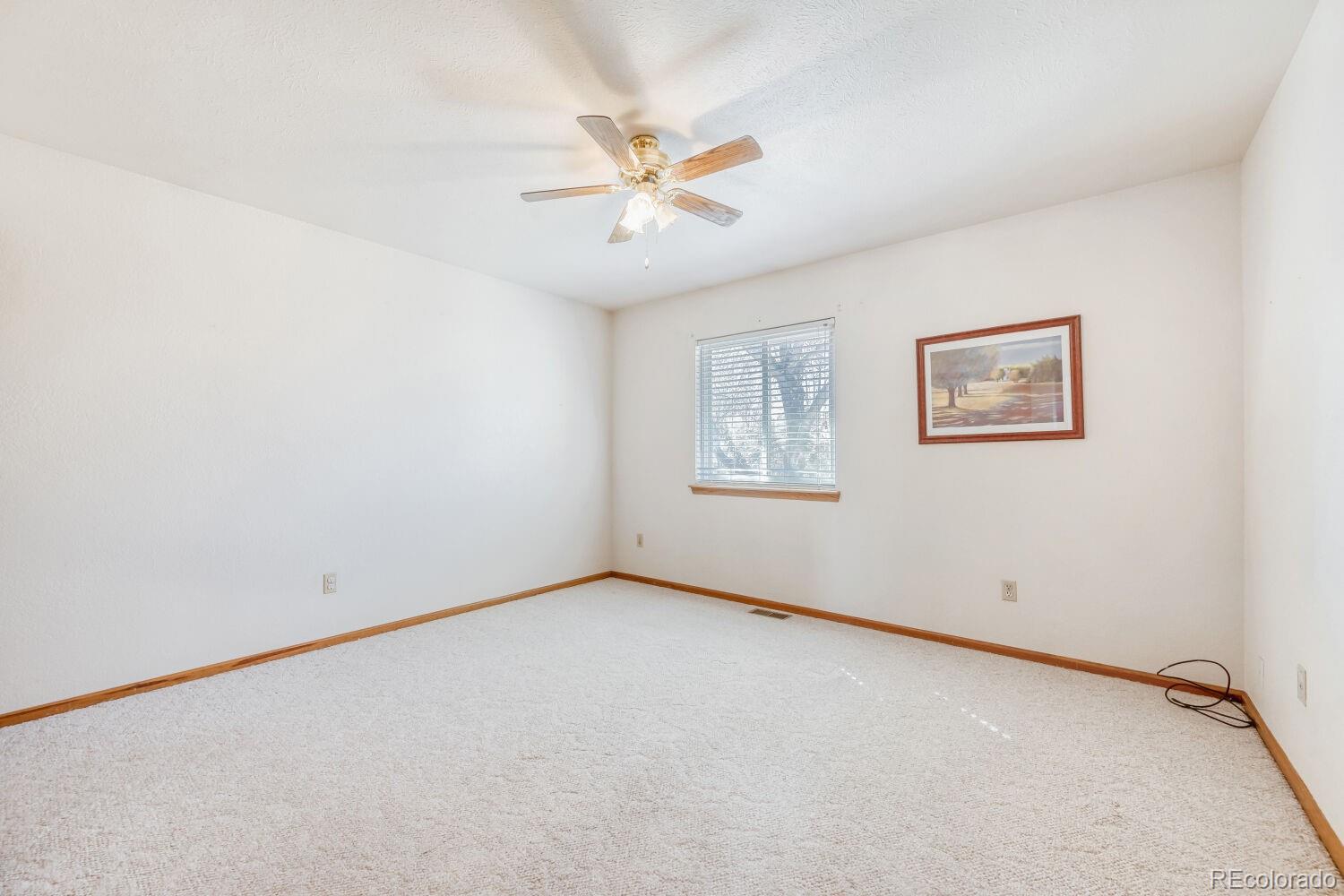 430 Elizabeth Street Fort Lupton, CO 80621 - Photo 18 of 30 an empty room with a window and a fan