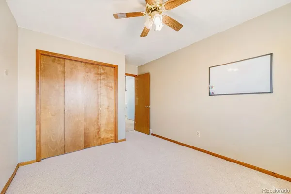 a view of a room with a ceiling fan and a window
