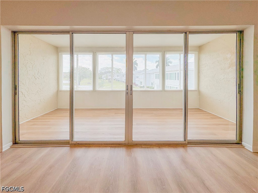 1830 Brantley Road, Unit I7 Fort Myers, FL 33907 - Photo 25 of 34 an empty room with wooden floor and windows