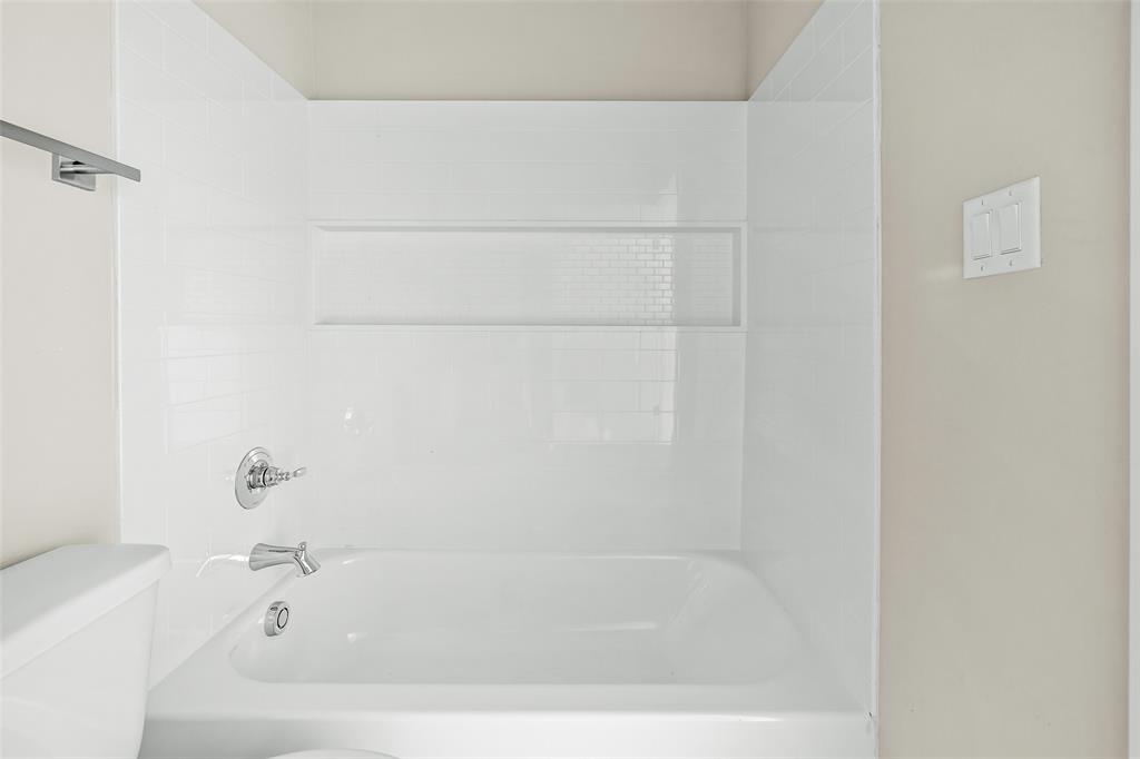 2290 West Tarleton Street, Unit 105 Stephenville, TX 76401 - Photo 11 of 15 a white bath tub and a shower