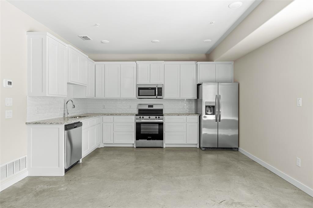 2290 West Tarleton Street, Unit 105 Stephenville, TX 76401 - Photo 4 of 15 a kitchen with cabinets stainless steel appliances and a window