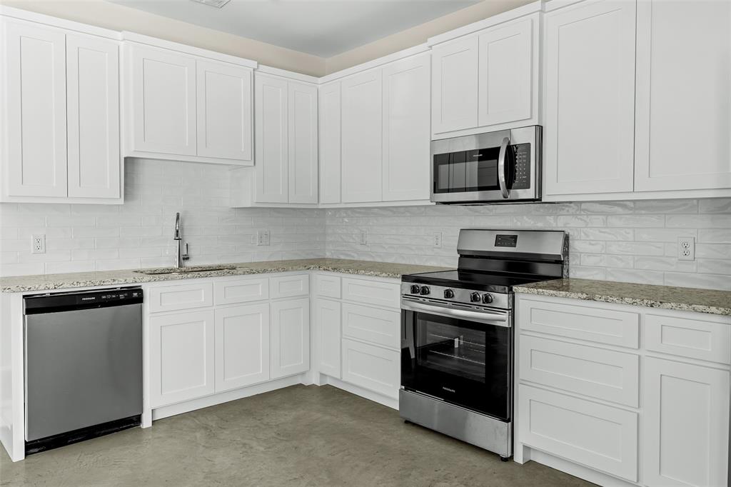 2290 West Tarleton Street, Unit 105 Stephenville, TX 76401 - Photo 7 of 15 a kitchen with white cabinets and stainless steel appliances