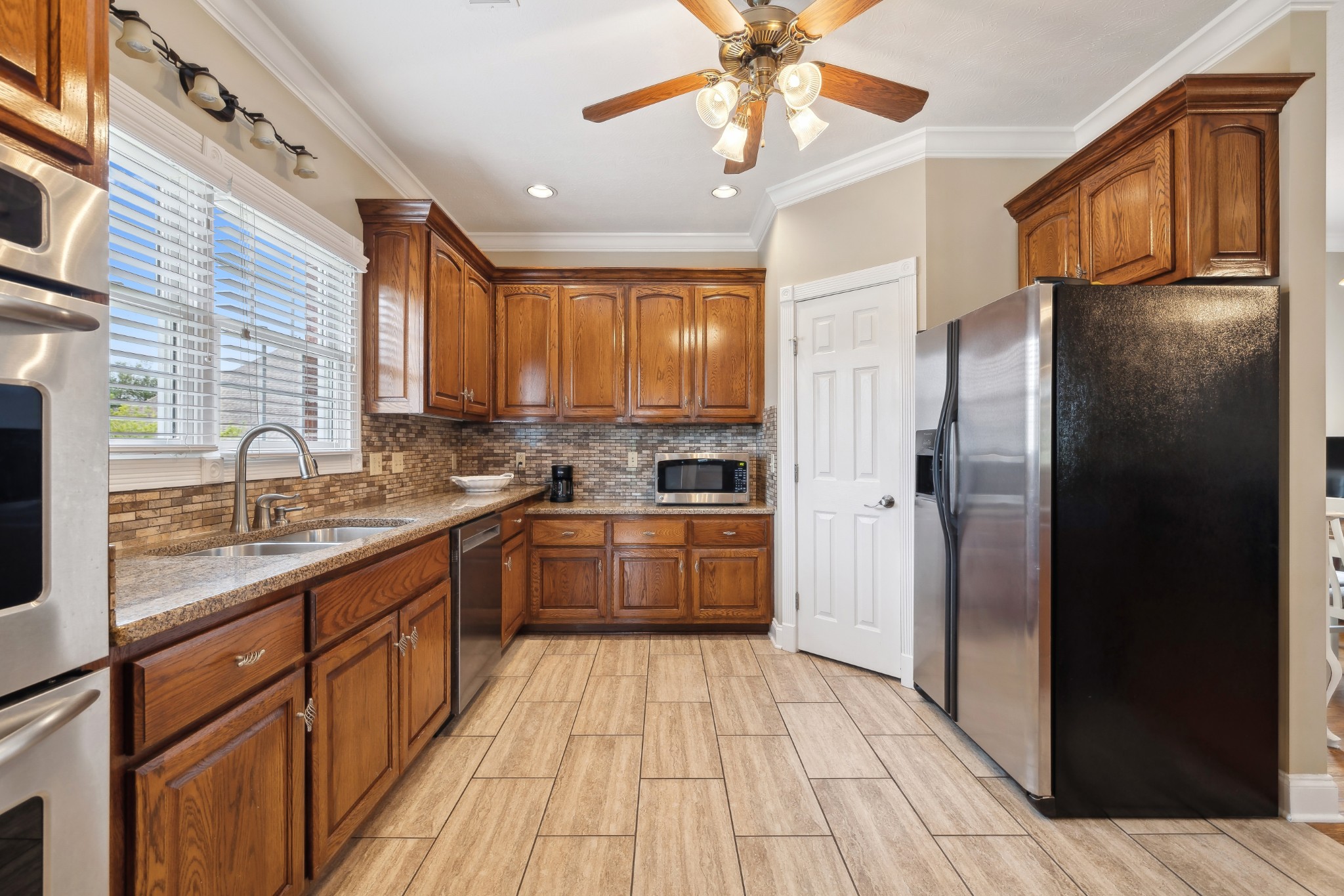 2108 Rodman Boulevard Gallatin, TN 37066 - Photo 16 of 45 a kitchen with stainless steel appliances granite countertop a refrigerator a sink dishwasher a stove with wooden cabinets and floor