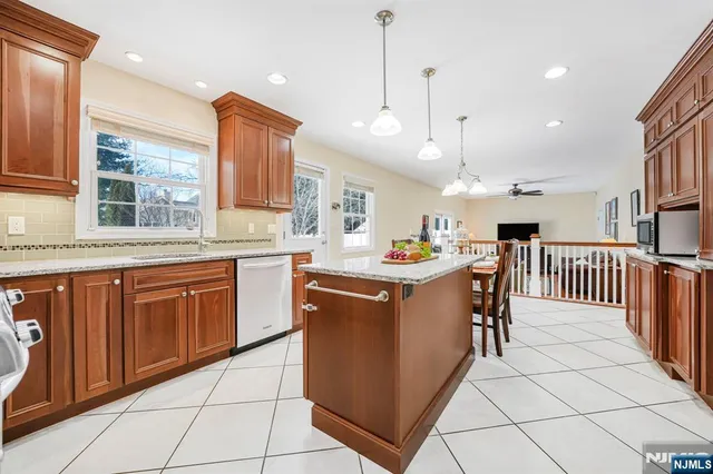 a kitchen with stainless steel appliances granite countertop a sink and a refrigerator