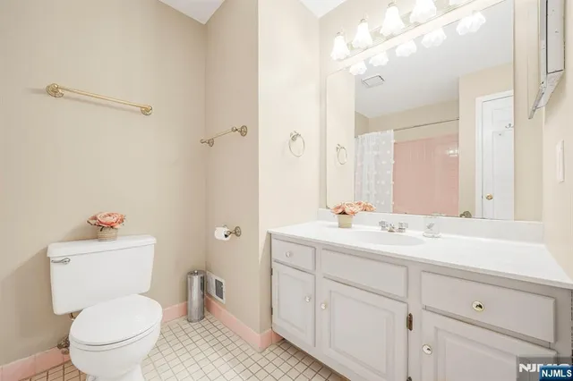 a bathroom with a toilet sink a mirror and vanity