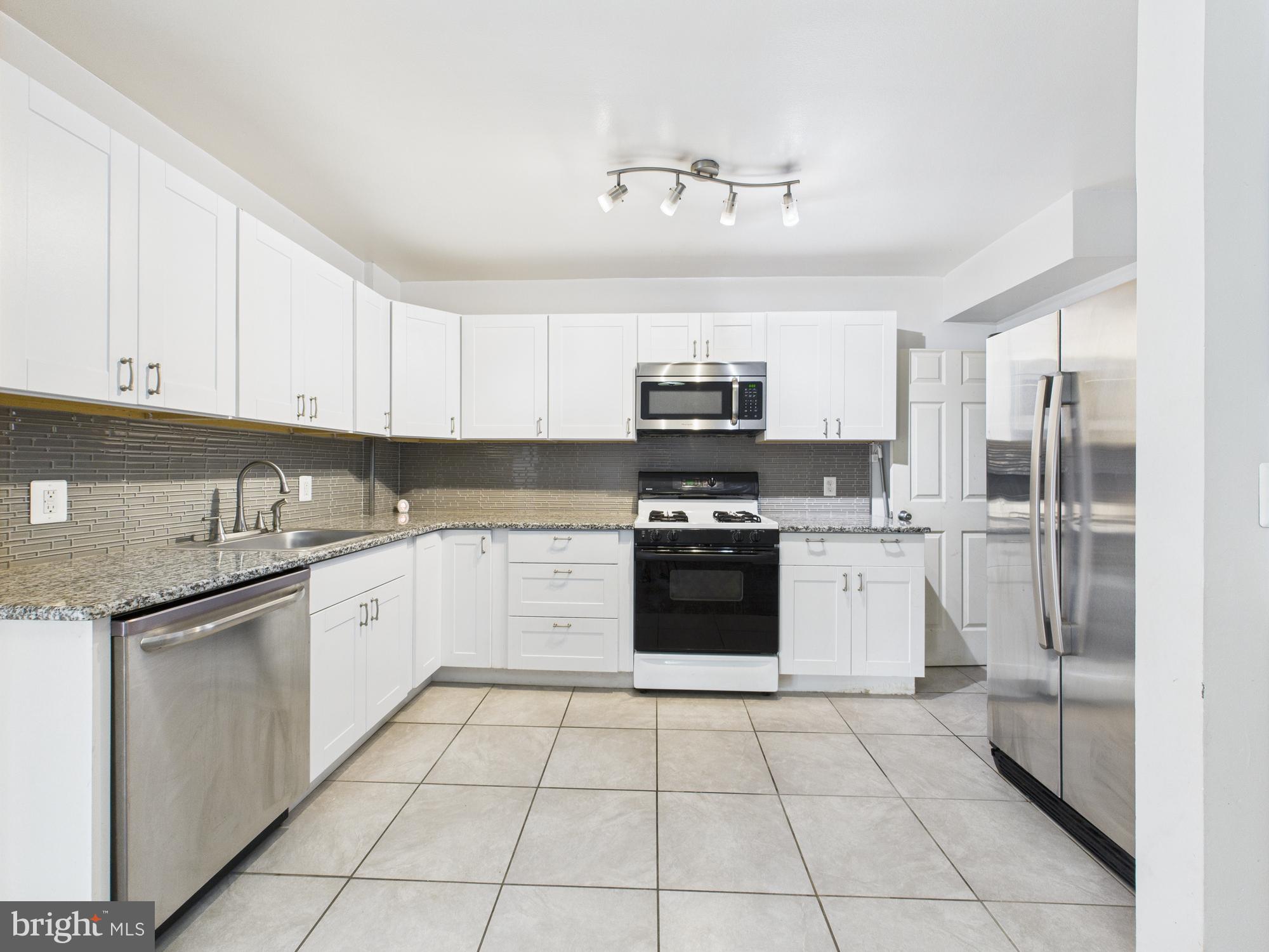 2743 Kirkleigh Road Dundalk, MD 21222 - Photo 13 of 31 a kitchen with granite countertop a stove top oven and cabinets