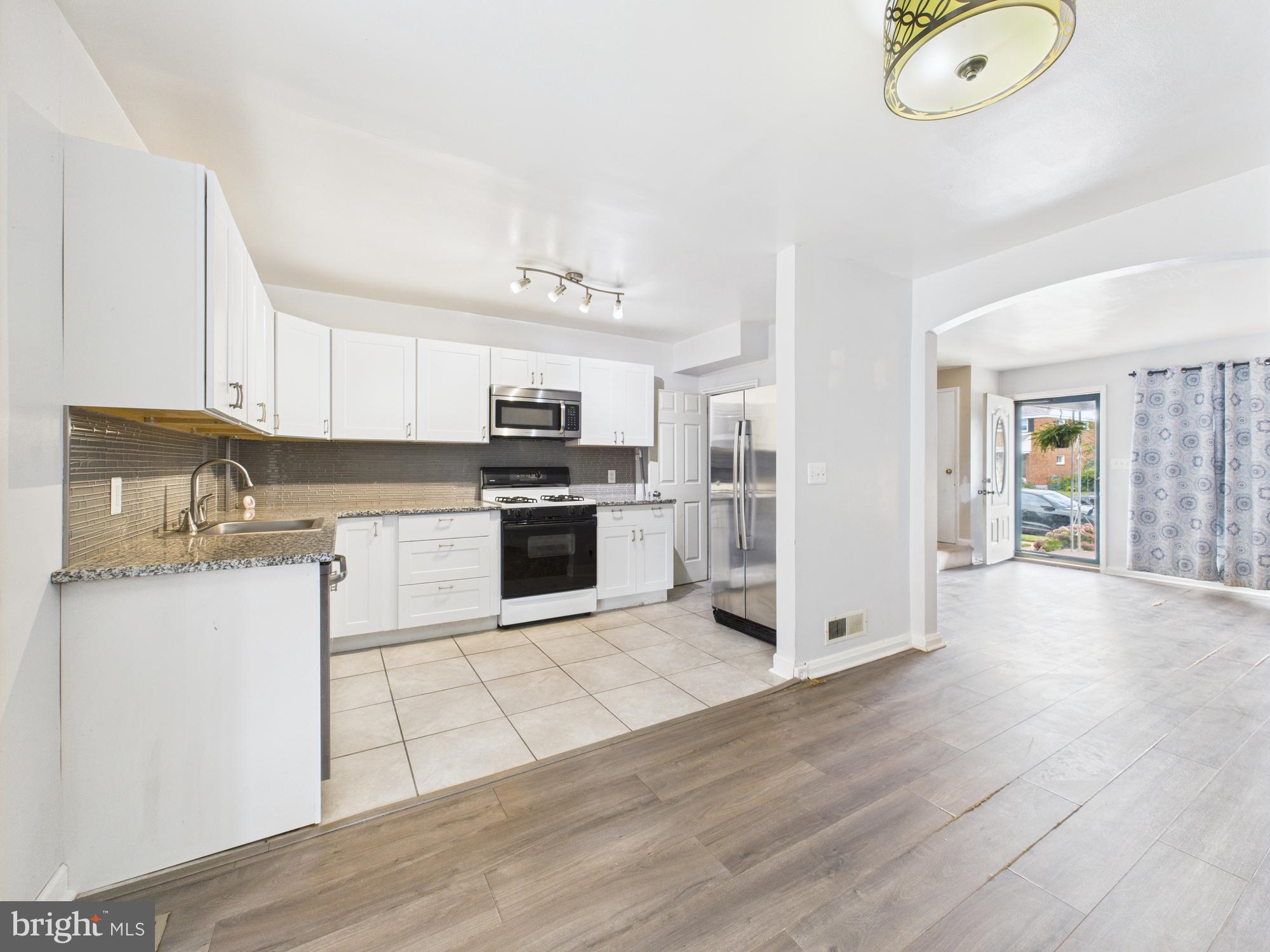2743 Kirkleigh Road Dundalk, MD 21222 - Photo 26 of 31 a kitchen with granite countertop a stove top oven and cabinets