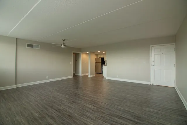 a view of an empty room with wooden floor