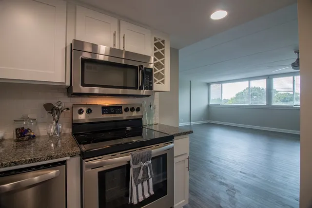 a kitchen with granite countertop a stove and a microwave