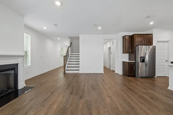 a view of a kitchen with stainless steel appliances wooden floor and staircase