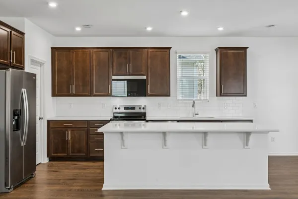 a kitchen with stainless steel appliances a sink stove and refrigerator