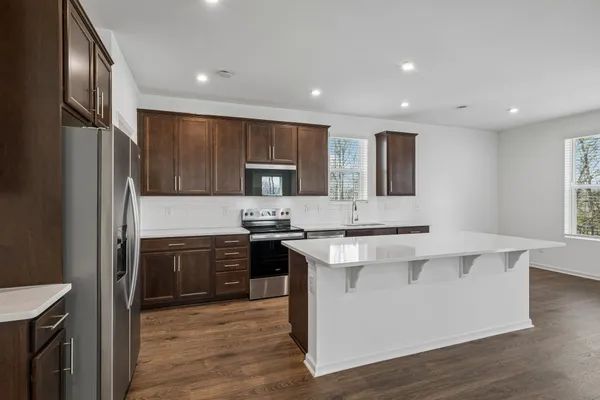 a kitchen with stainless steel appliances granite countertop a sink stove and refrigerator