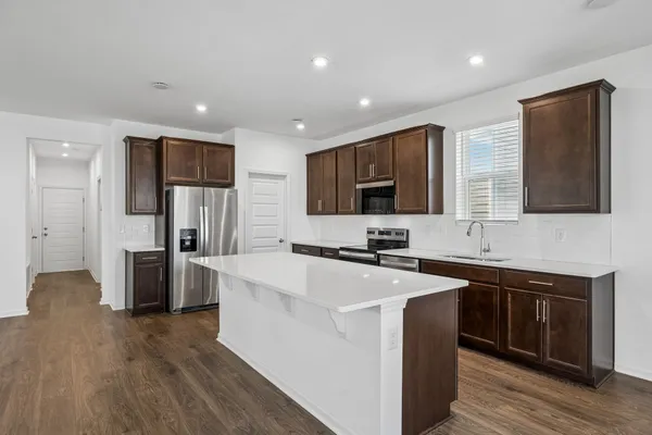 a kitchen with a sink a counter top space stainless steel appliances and cabinets