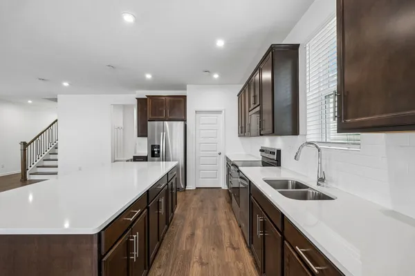 a kitchen with stainless steel appliances granite countertop sink stove top oven and refrigerator