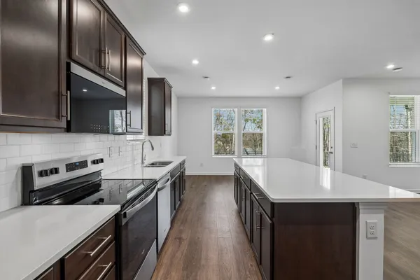 a kitchen with stainless steel appliances granite countertop a sink stove and refrigerator