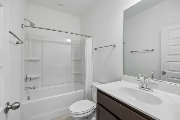 a bathroom with a sink toilet tub vanity and shower