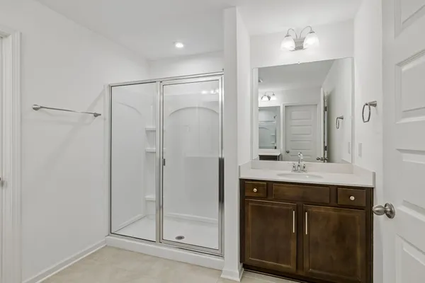 a bathroom with a shower sink and mirror
