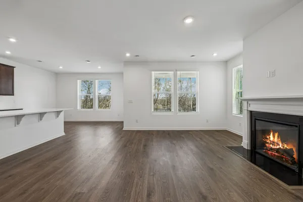 an empty room with windows and a fireplace