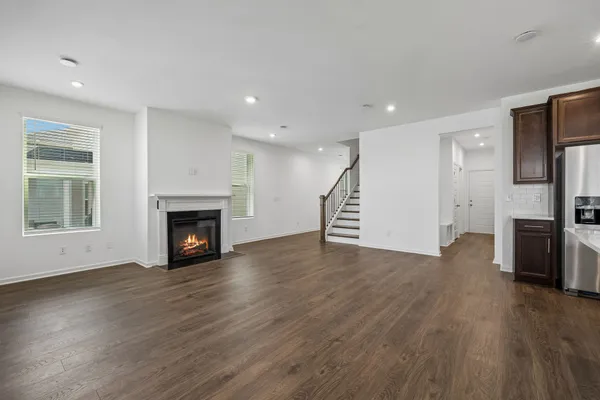 a view of empty room with wooden floor and fireplace