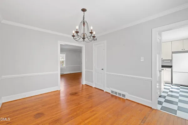 a view of a livingroom with wooden floor and a chandelier