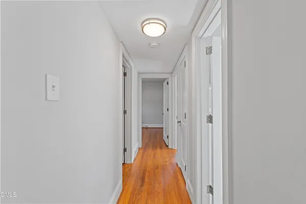 a view of a hallway with wooden floor and closet