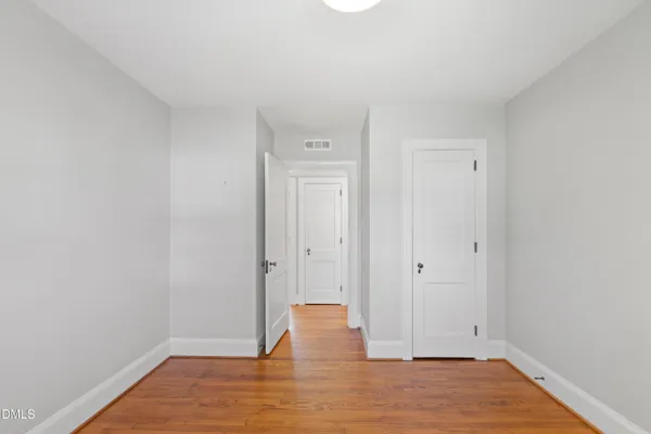 a view of empty room with wooden floor