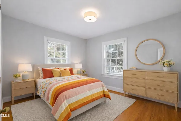 a bedroom with a bed a dresser and a window