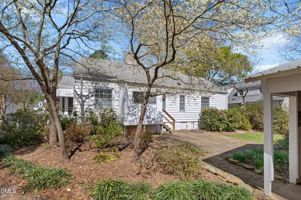 a view of a house with a yard and tree