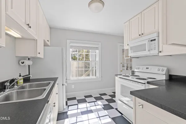 a kitchen with granite countertop a sink stove and cabinets