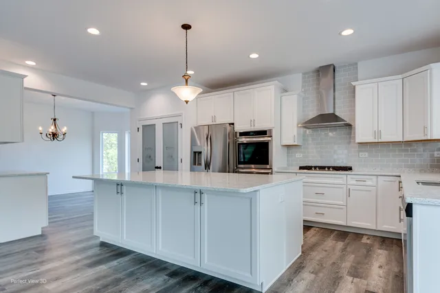 a kitchen with stainless steel appliances granite countertop a stove a sink and a refrigerator